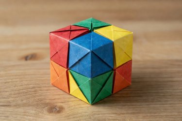 Completed geometric sonobe origami cube made from six folded colored paper units